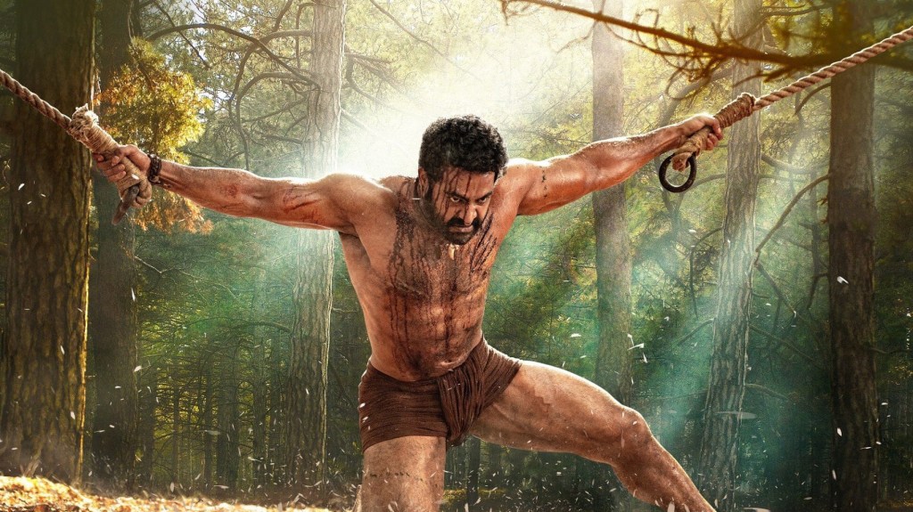 A production still from RRR. Bheem holding two ropes together with his own bare hands.
